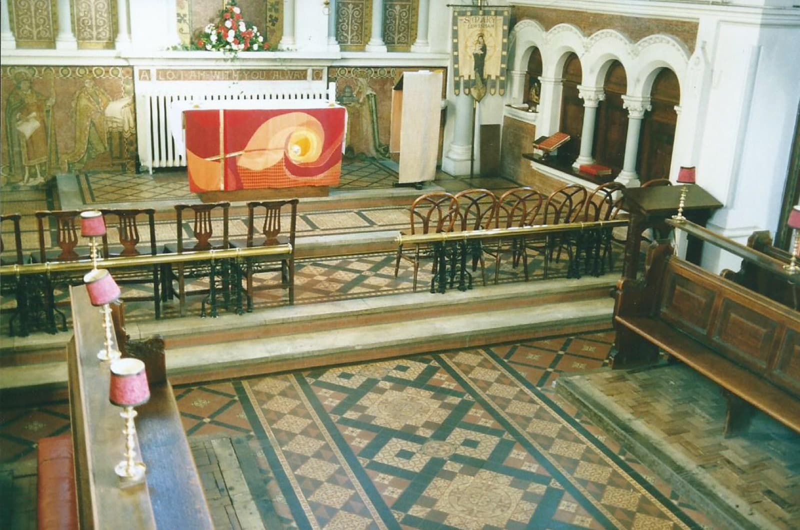 The chancel before the re-ordering: a patterned tiled floor, choir stalls facing each other, and an altar with a red frontal.