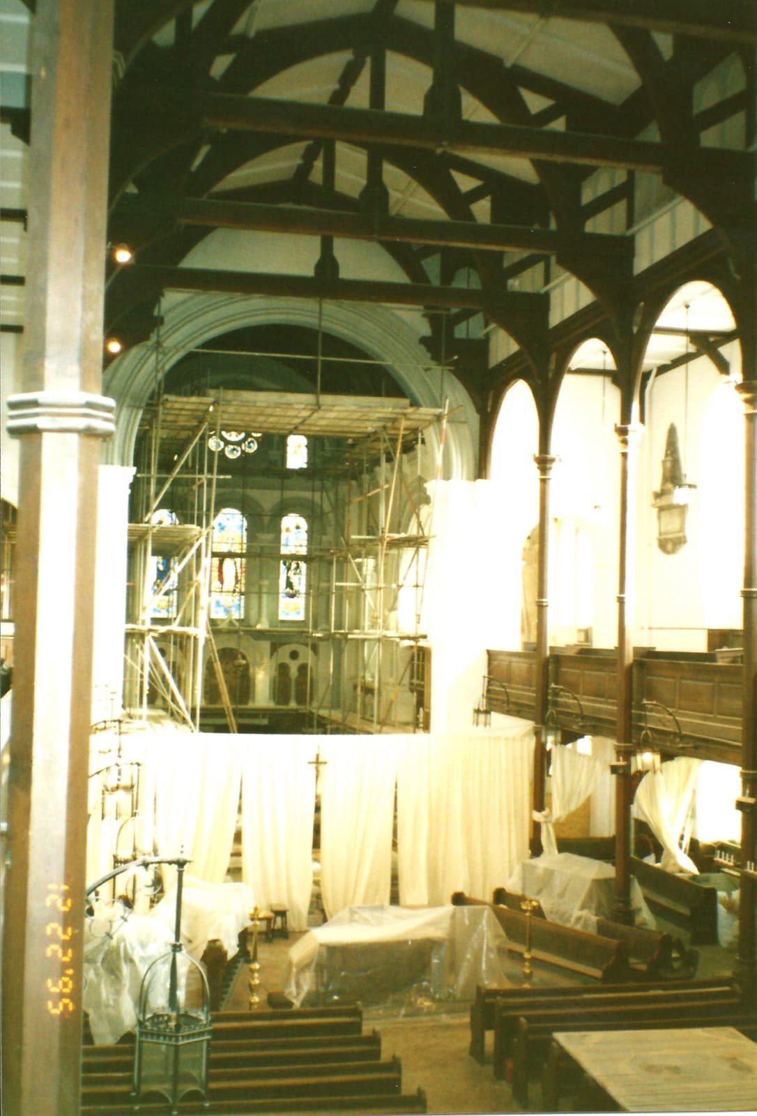 The interior of the church filled with scaffolding during building work, the arcades and windows visible behind.