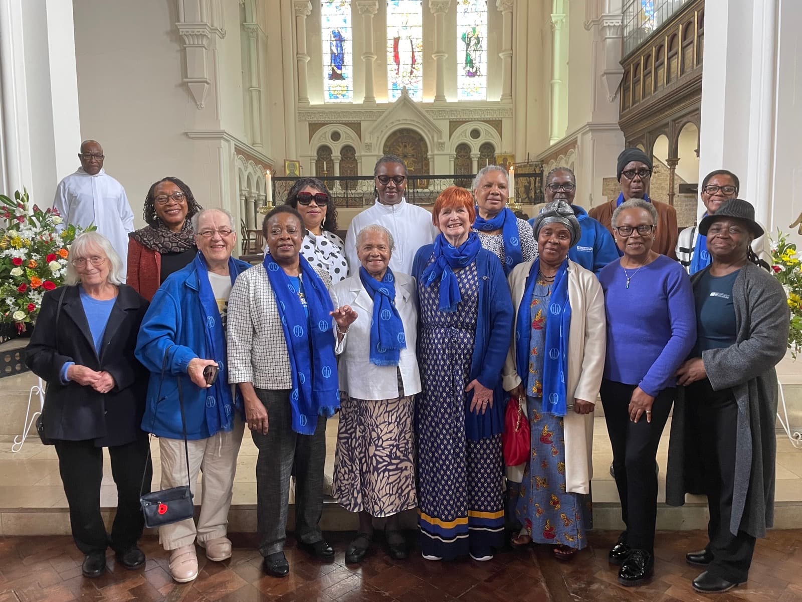 Members of the Mothers' Union branch standing together in church, many wearing the blue of the organisation.