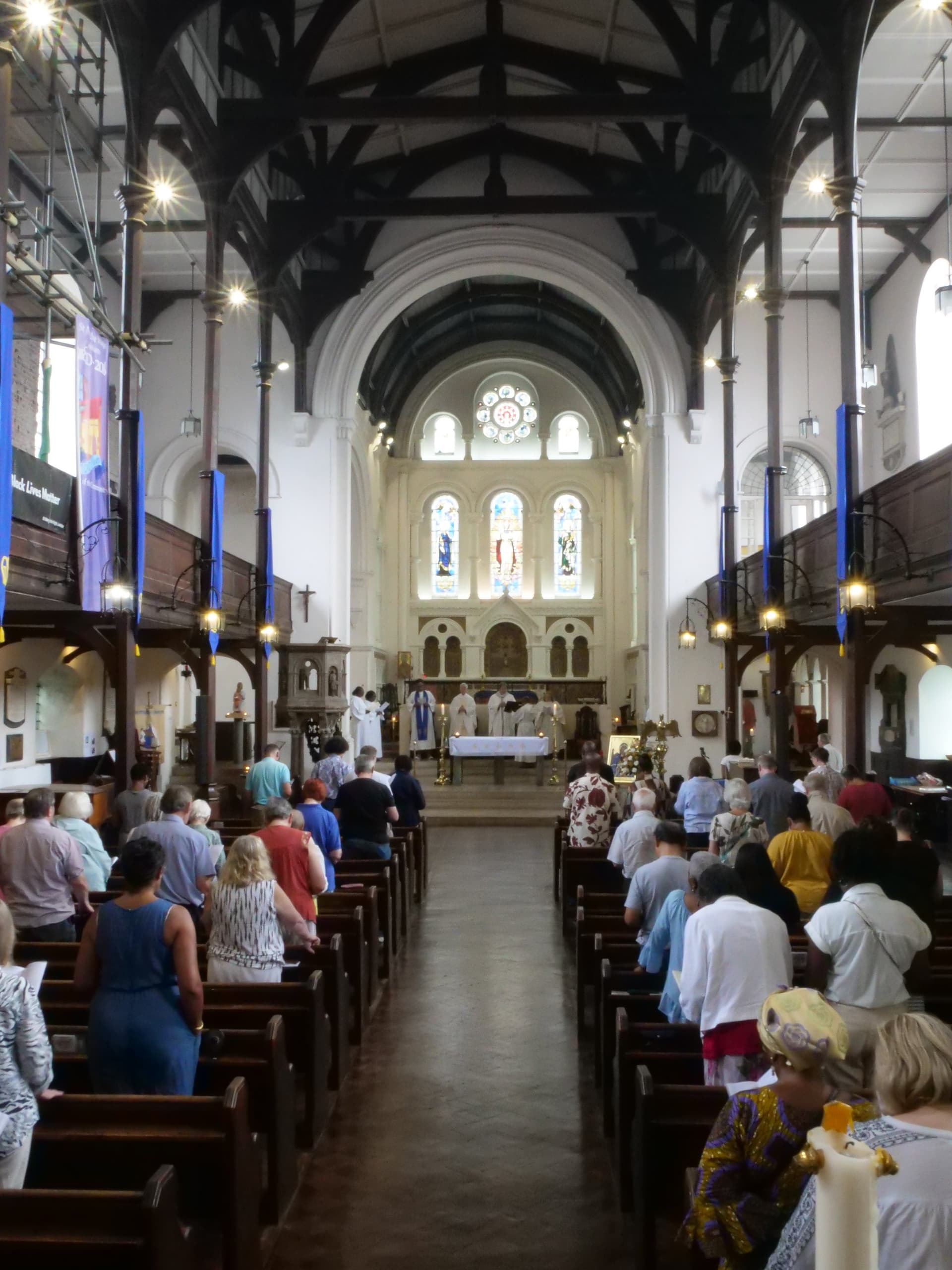 The nave of St Mary the Virgin looking east during the Sunday mass, showing the timber roof, the galleries and the congregation.