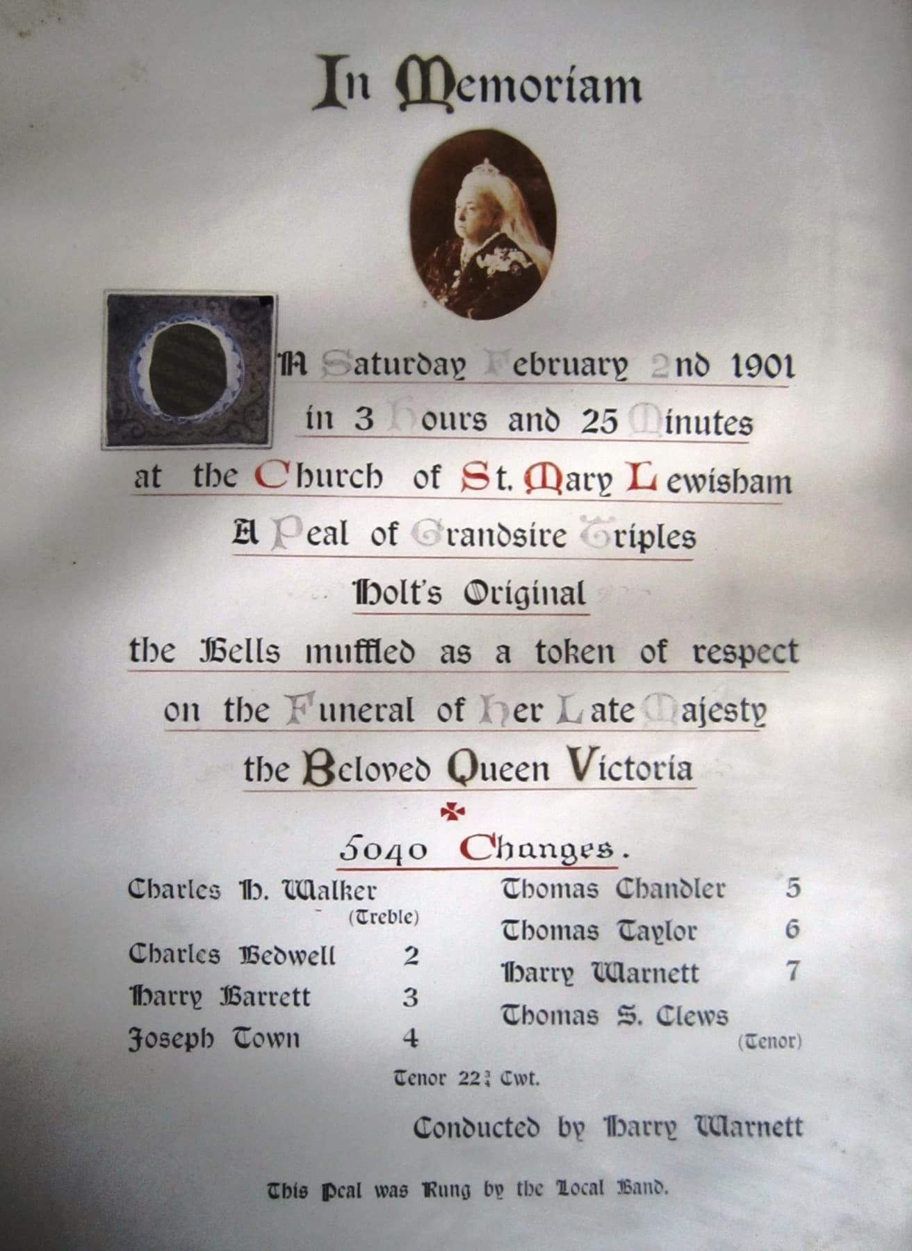 A painted peal board headed 'In Memoriam' with an oval portrait of Queen Victoria, recording a peal rung at St Mary Lewisham on 2 February 1901 with the bells muffled for her funeral, and naming the eight ringers.