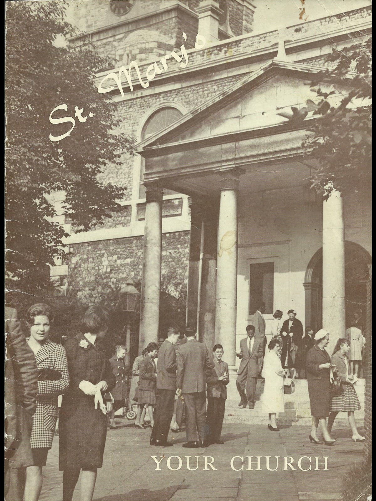 The cover of a parish booklet titled St Mary's, Your Church. A crowd is coming out of the west portico of the church after a service in about 1960 — women in coats and hats carrying gloves and handbags, boys in school blazers, children, and a man in a light suit coming down the steps. The congregation is Black and white together.