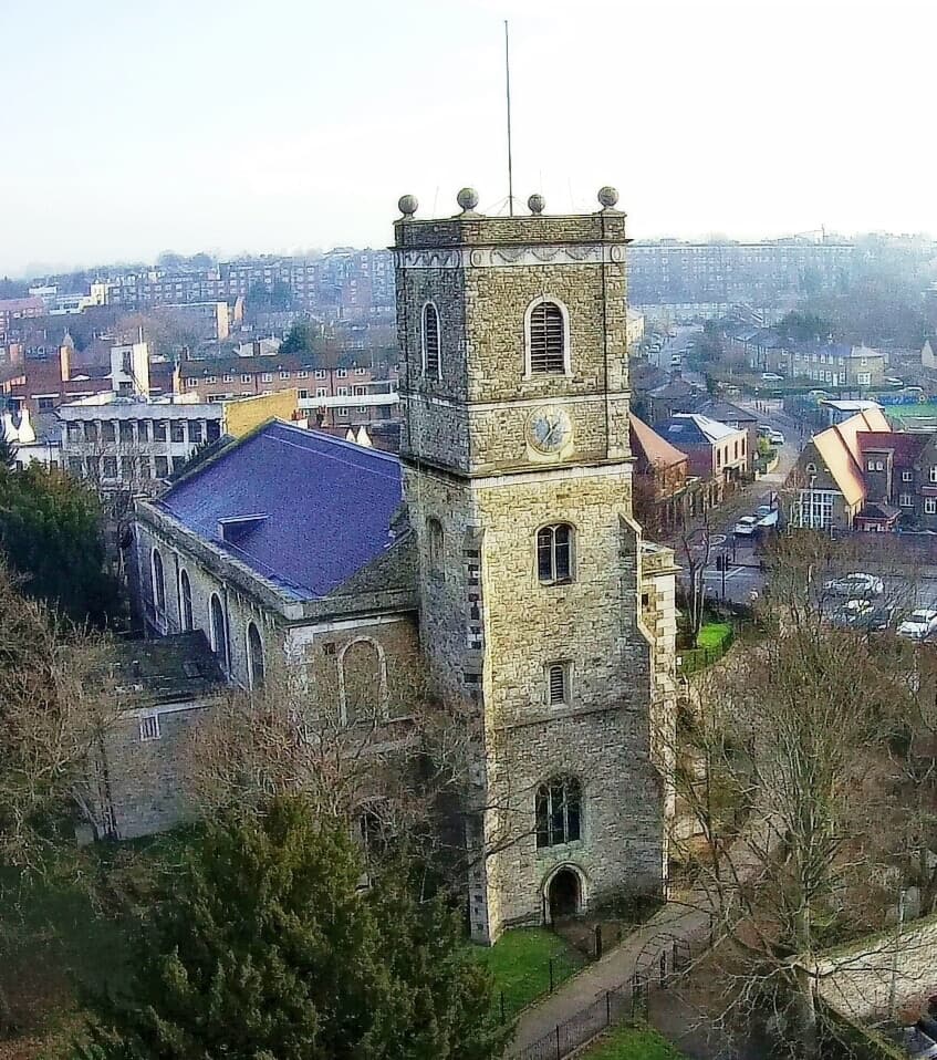 The tower of St Mary the Virgin seen from the churchyard on a clear morning.
